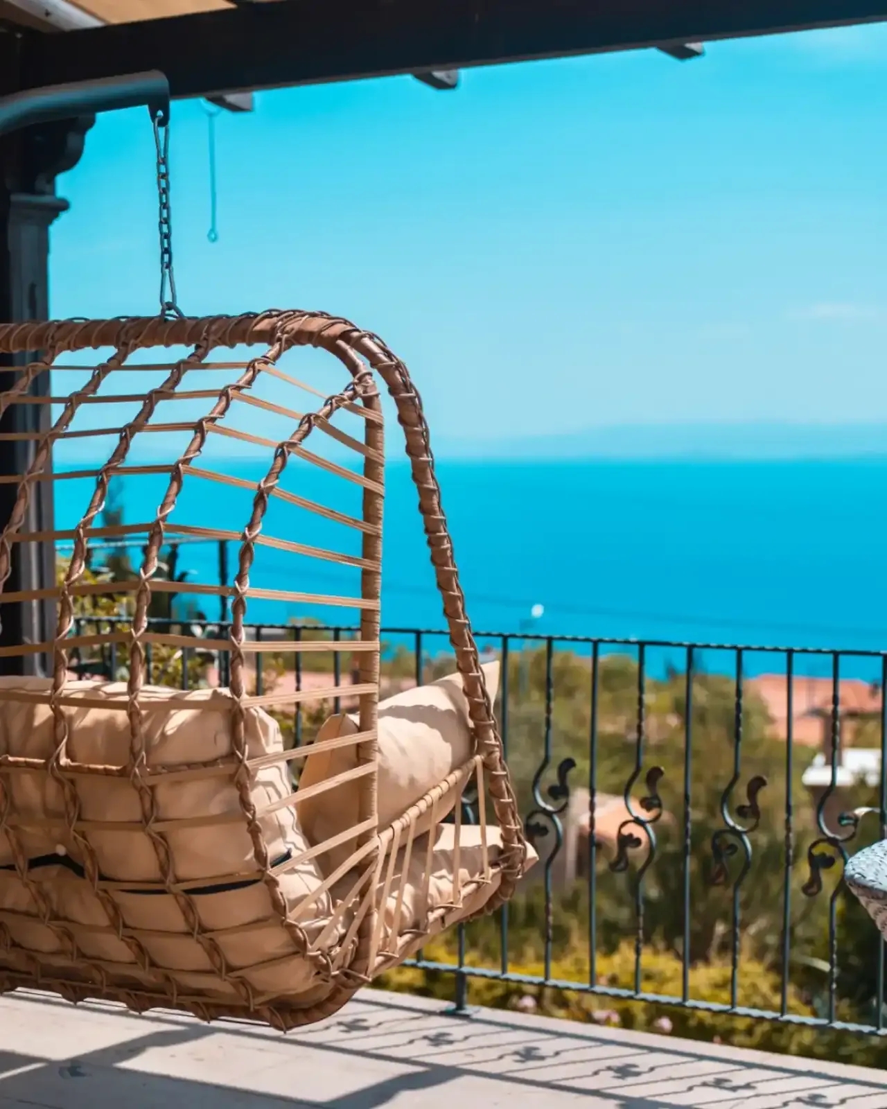 A wicker swing on the terrace facing the sea