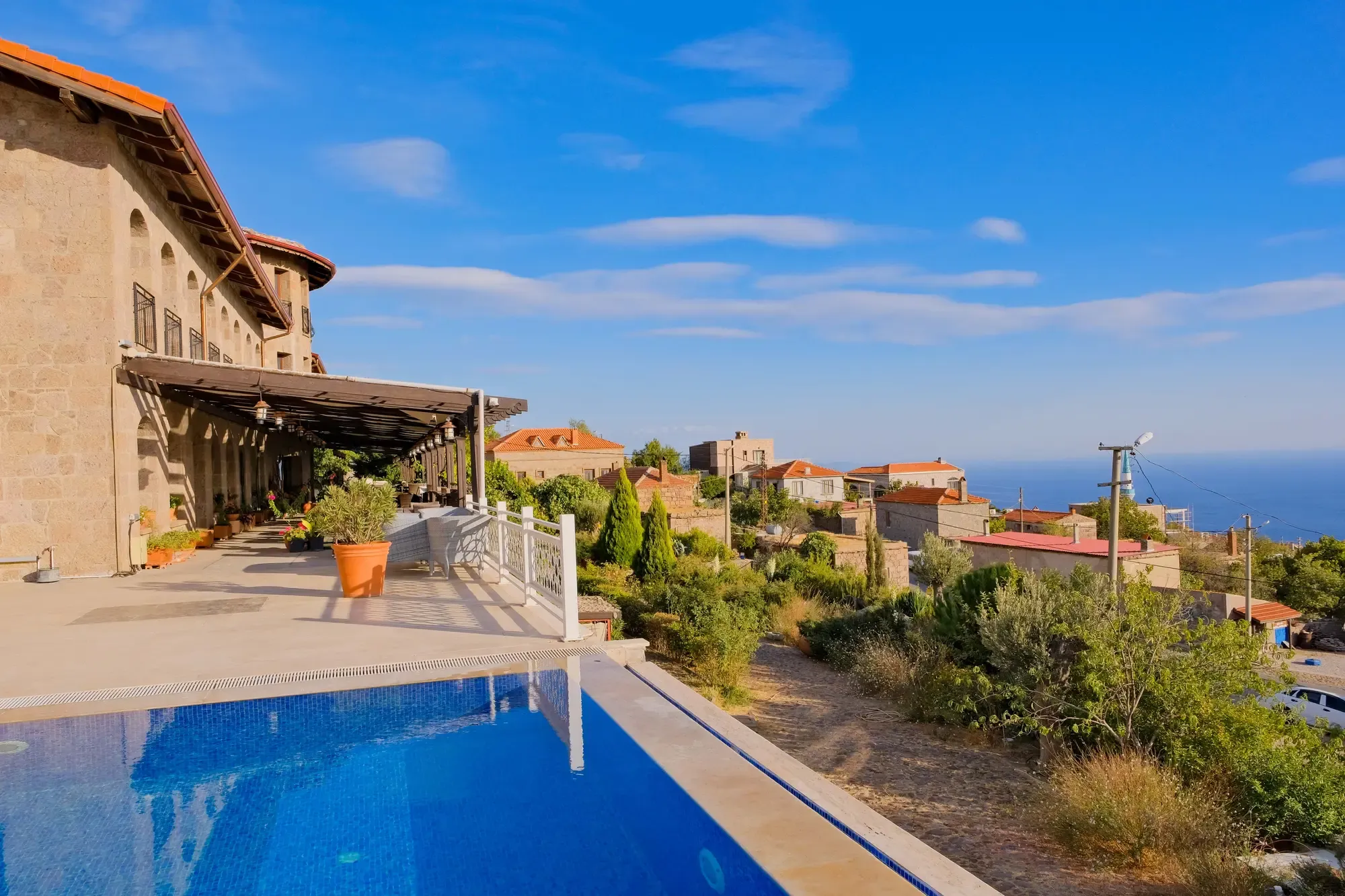 Pool and stone hotel facing the Aegean