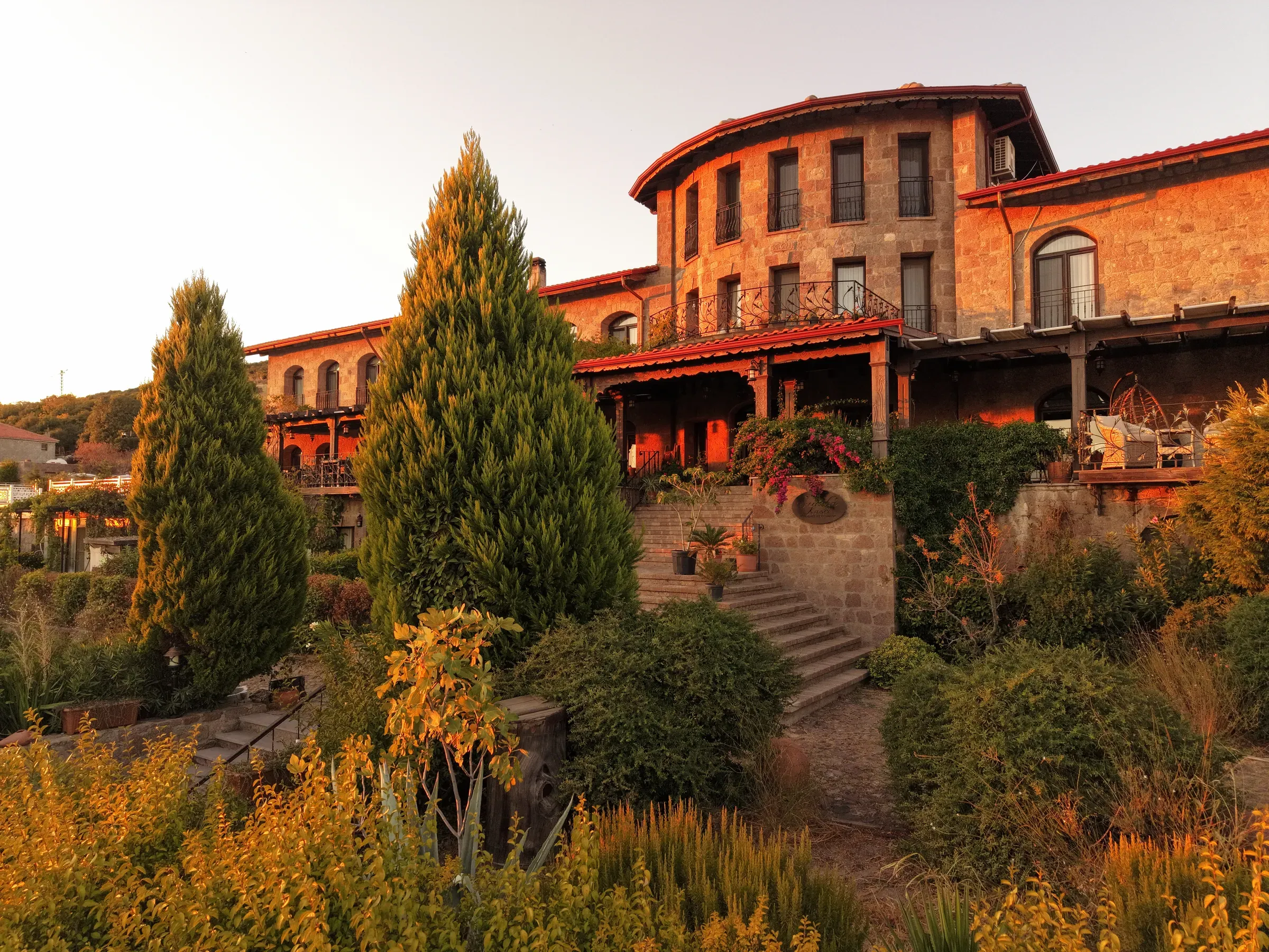 The stone hotel and garden steps at sunset