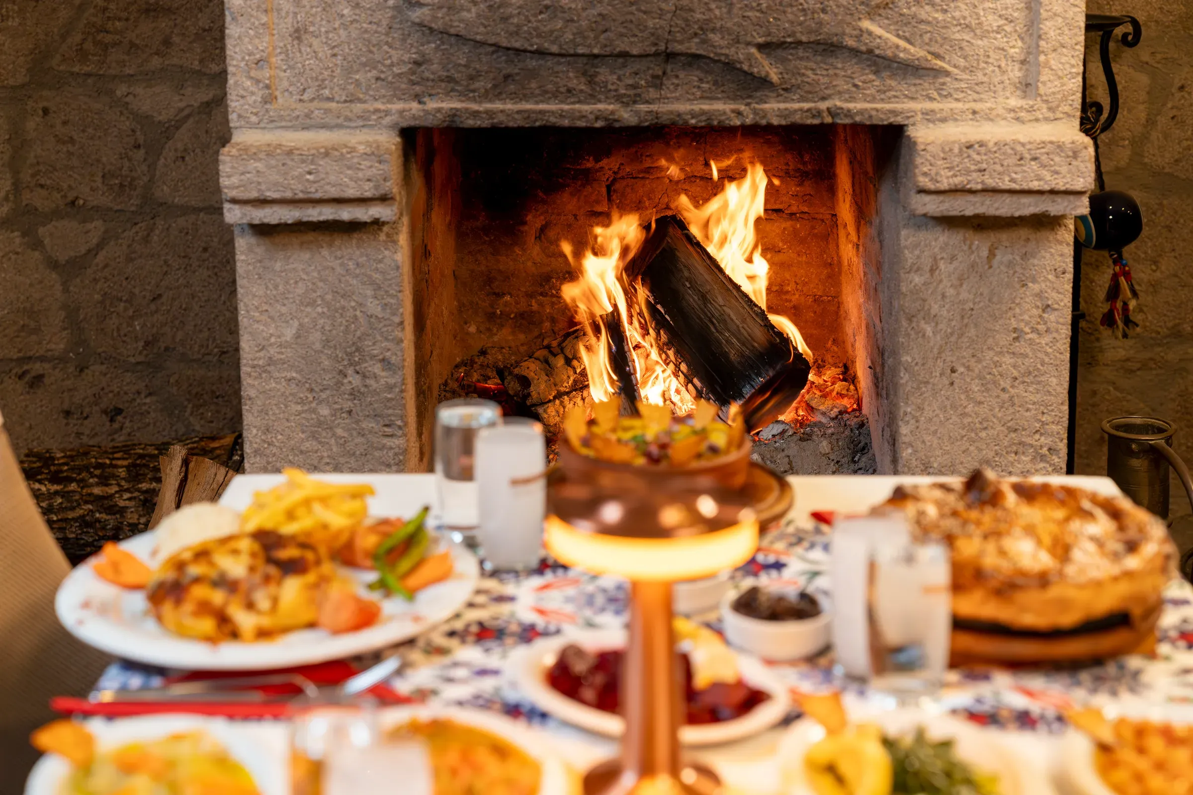 A table set in front of the lit fireplace