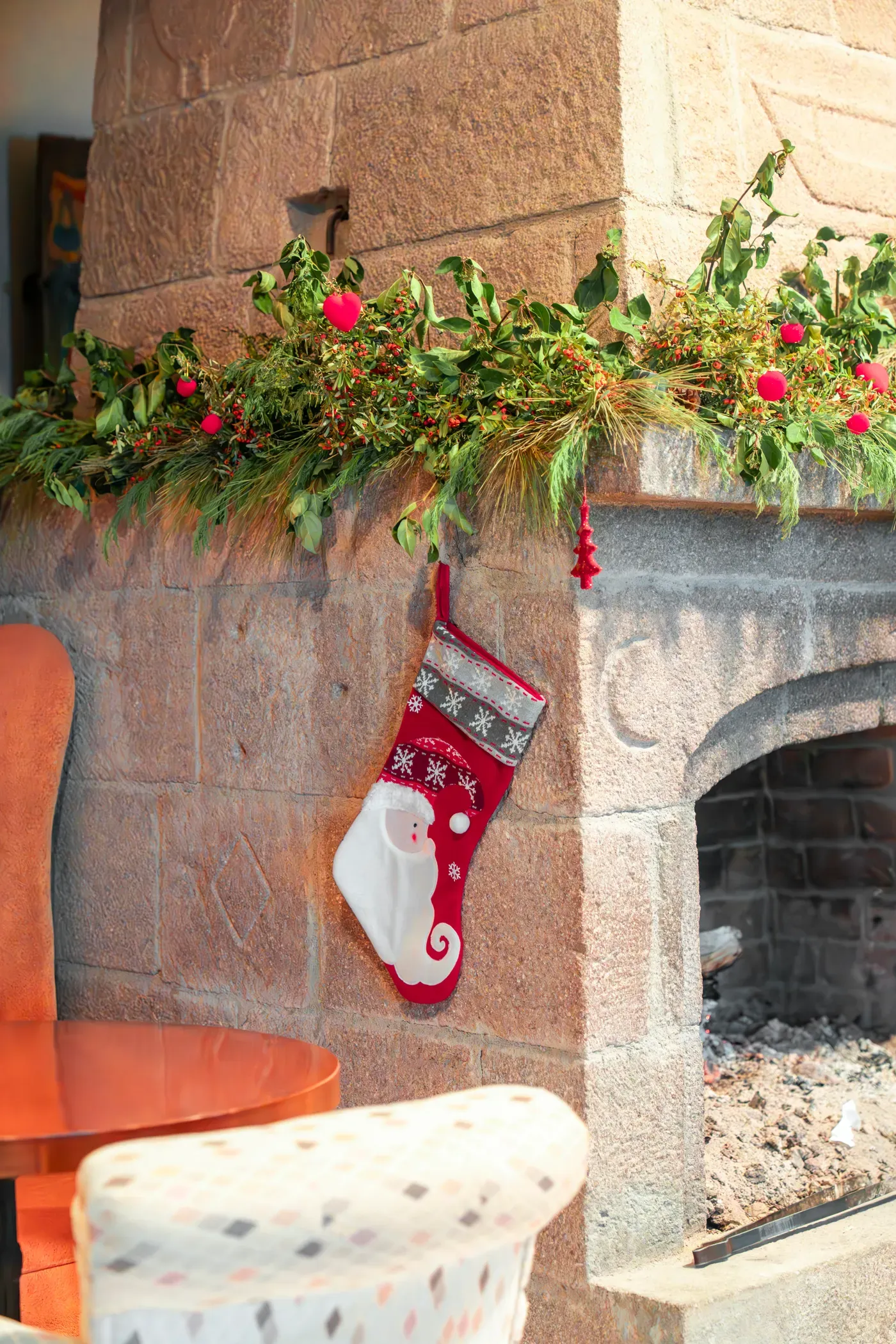 Green garland and a stocking on the fireplace